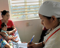 Health worker taking notes, bedside